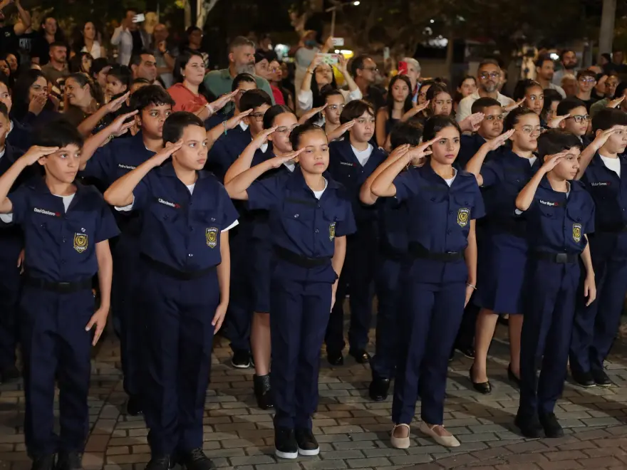Alunos fardados prestando continência em formatura